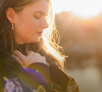 Woman with a blurred background, possibly at sunset or sunrise